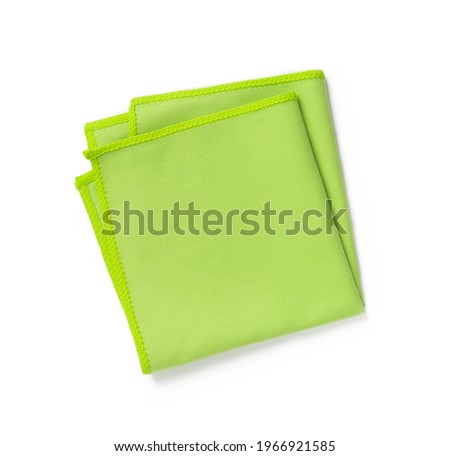 Green microfiber cloth folded in four isolated on white background. New microfiber soft material for cleaning objects and surfaces. Housework, cleaning and purity equipment. Top view.  Royalty-Free Stock Photo #1966921585