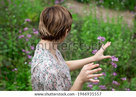 Caucasian short hair girl in nature, surrounded by violet flowers in spring.