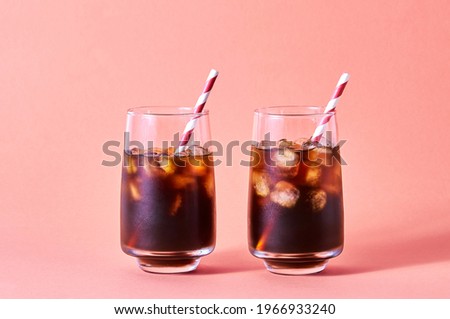 Iced Cola or Cold Coffee in Tall Glasses on Pink Background. Concept Refreshing Summer Drink
