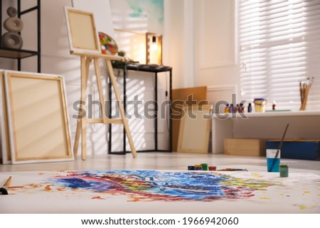 Abstract picture and wooden easel in art studio