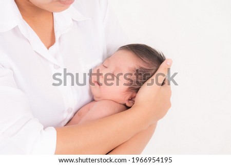 Portrait of woman and little baby, Newborn resting in mother's arm with studio shot isolated on white background.