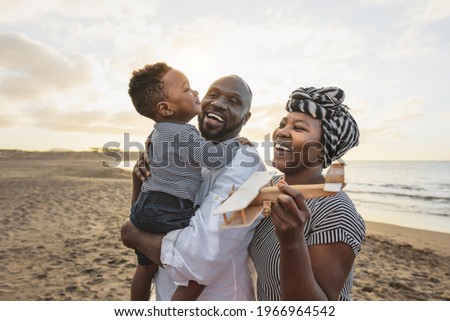 Happy African family having fun on the beach during summer vacation - Parents love and unity concept Royalty-Free Stock Photo #1966964542