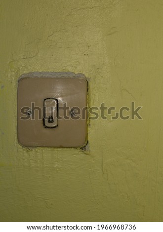  very old doorbell with yellow wall