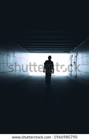 Silhouette of a woman walking in the underpass