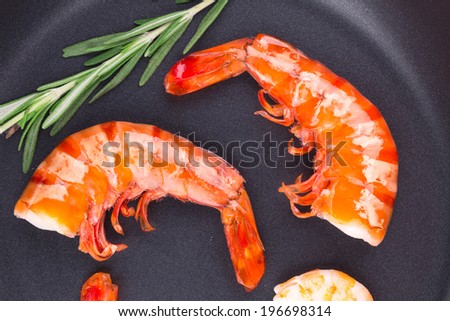 Fragment of cooked unshelled shrimps on frying pan. Whole background.