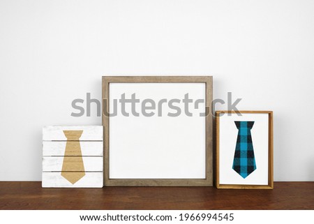 Mock up wood frame with rustic Fathers Day tie decor. Wooden shelf against a white wall. Copy space.
