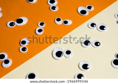 A bunch of toy eyes on an airtight two-color background split in half