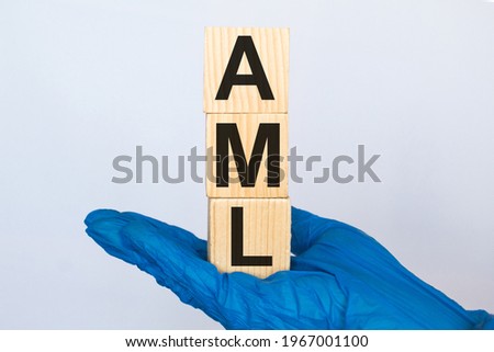 A doctor wearing gloves holds wooden cubes with the inscription AML, medical concept