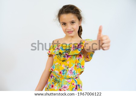 Portrait of a beautiful and confident girl showing thumb up isolated over white background