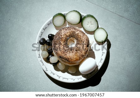 Bagel with poppy seeds and garnish, breakfast setup