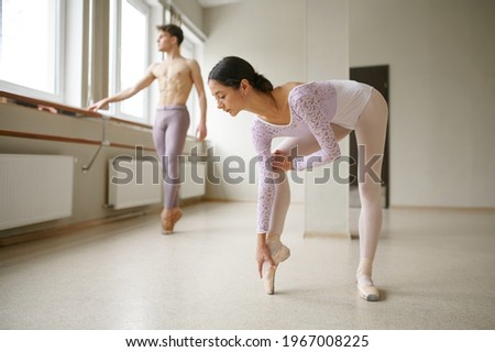 Couple of ballet dancers, stretching exercises