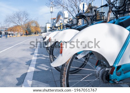 selective focus of a lot of rear wheels of rent and share bicycles parked on the street low angle