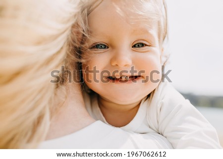Closeup of a little girl, smiling, showing her first teeth growing.