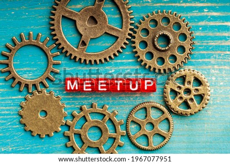 gears around the lettering Meetup on a blue wooden background. teamwork