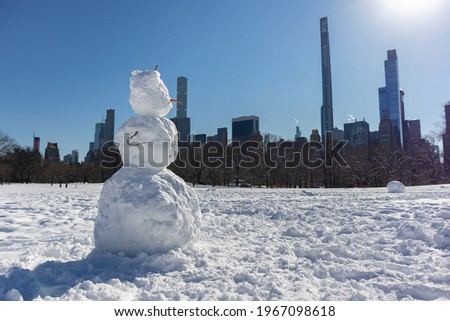 Snowman on the Sheep Meadow at Central Park in New York City during the Winter with the Midtown Manhattan Skyline in the Background