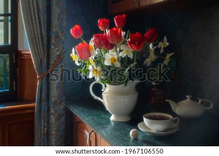 Still life with bouquet of spring garden flowers and tea cup