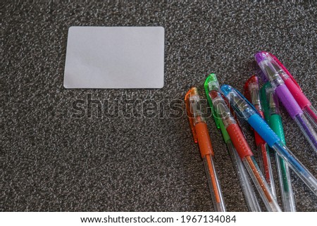 Colored pens on a gray background.