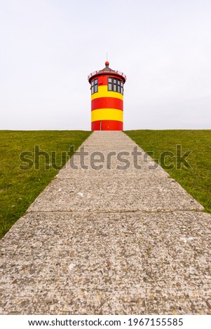 The Pilsumer lighthouse in Greetsiel, Krummhorn, Lower Saxony, Germany Royalty-Free Stock Photo #1967155585