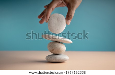 Life Balance Concept. Hand Setting White Natural Zen Stone Stack. Balancing Mind, Soul and Spirit. Mental Meditation Practice Royalty-Free Stock Photo #1967162338