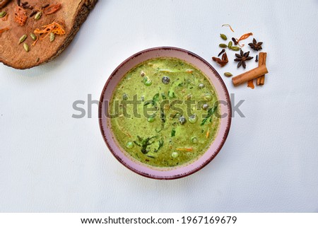 THai Green beef,Green curry, Thai green curry with beef chilli and eggplant garnished with slice fresh chilli and Basil leaf in black colour bowl on white background with spicy.

