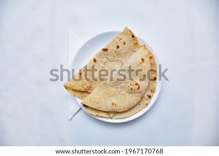 Indian vegan diet meal- fresh organic whole wheat chapathi or chapati served with delicious vegetable curry and chickpeas channa masala.
with wood plate and whit