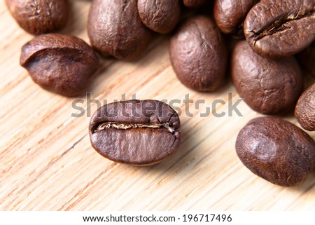 coffee beans on wooden table , focus on foreground