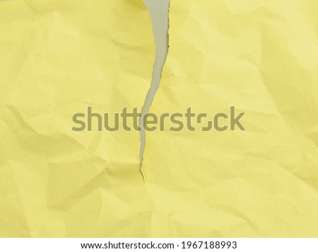 blank torn crumpled yellow sheet of paper on a gray background, copy space