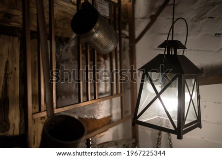 Kirzhach, Vladimir region, Russia - April, 2021: An antique lamp with an electric lamp hangs on the wall of a wooden house.