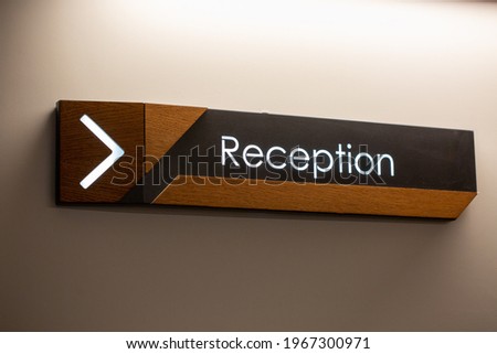 The reception sign with direction arrow on the wall