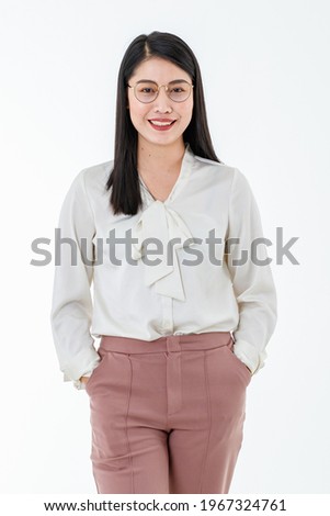Asian adorable business working woman wearing white shirt, pink pants, posing with confidence and wearing eyeglasses while looking to camera and standing on  white background