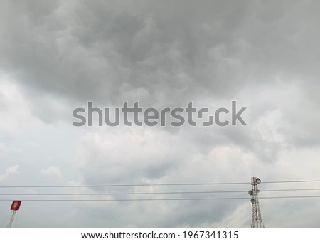 The picture of the sky, cloud, dark before it rains in Thailand and the birds on the wires.