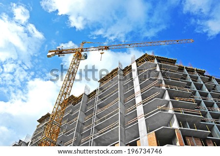 Crane and building construction site against blue sky Royalty-Free Stock Photo #196734746