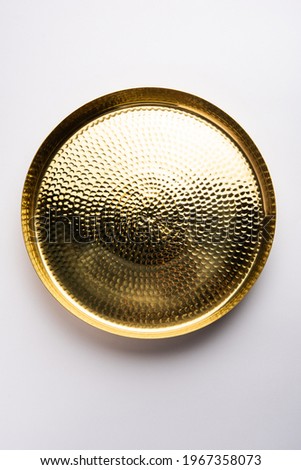 Empty oval or round shape thali or plate made up of brass, pital or gold over white background Royalty-Free Stock Photo #1967358073