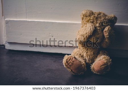 Abandoned Teddy Covering His Eyes, Sitting At A Door - Child Abuse Concept Royalty-Free Stock Photo #1967376403