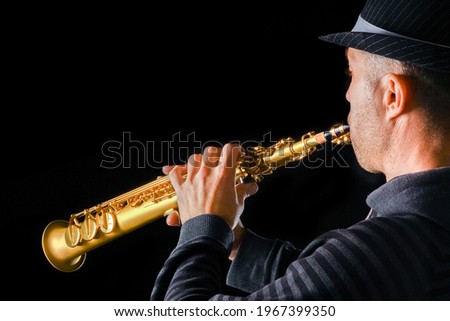 soprano saxophone in the hands of a guy on a black background Royalty-Free Stock Photo #1967399350