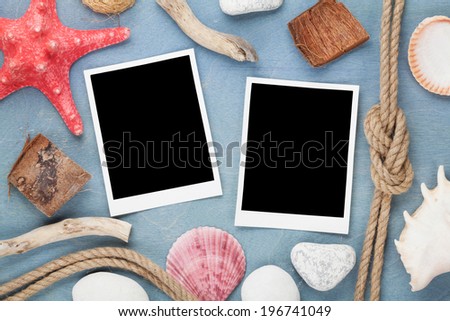 Travel photo frames on blue wooden texture with seashells and rope around