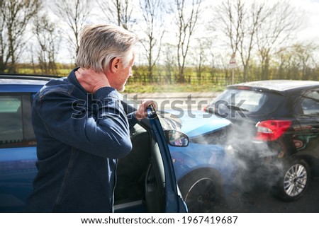 Senior male driver with whiplash injury getting out of car after traffic accident Royalty-Free Stock Photo #1967419687