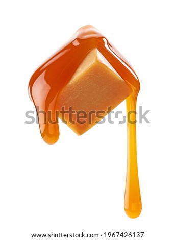 caramel sauce flowing on flying caramel candy isolated on white background Royalty-Free Stock Photo #1967426137