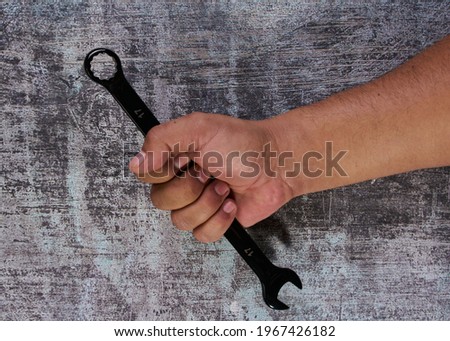 Hand holding tool to remove nuts and bolts                        