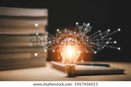 Thinking and creative concept, Light bulb on the Book and light bulb style bokeh vintage dark background,Concept The idea of reading books, knowledge, and searching for new ideas. Royalty-Free Stock Photo #1967436013