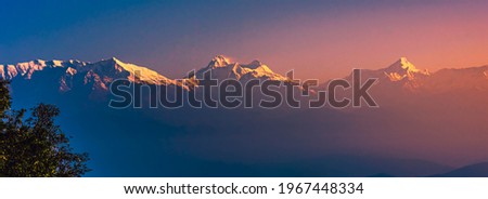 View of Himalayas mountain range with visible silhouettes through the colorful fog at Binsar, a hill station in Almora district, Uttarakhand, India. Royalty-Free Stock Photo #1967448334