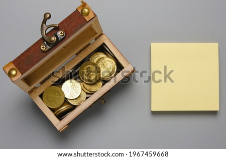 A picture of copyspace notepad with gold coin in chest insight. We buy value, we sell trust concept.