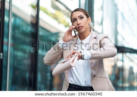 Business woman rushing and talking on phone outdoors Royalty-Free Stock Photo #1967460340