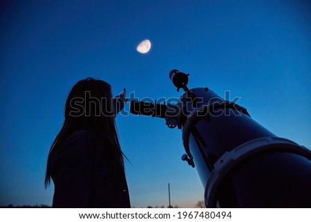 Woman looking at night sky with amateur astronomical telescope. Royalty-Free Stock Photo #1967480494