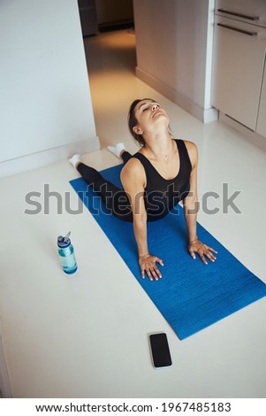 Beautiful sporty woman practicing yoga at home