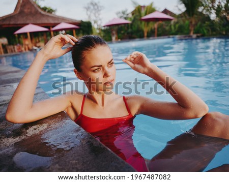 women on the beach leaning on the tiles of the pool clear water model sun lounger