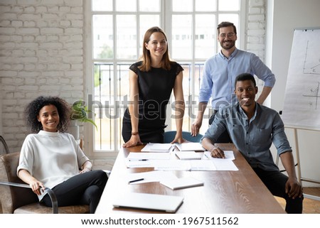 Portrait of happy mixed race motivated successful colleagues employees looking at camera, posing together in modern office, company staffing, international career opportunities, collaboration concept. Royalty-Free Stock Photo #1967511562