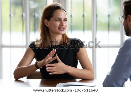 Confident young businesswoman sitting at table, holding negotiations meeting with male partner, discussing collaboration issues. Skilled female hr manager involved in job interview with candidate. Royalty-Free Stock Photo #1967511640