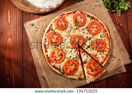 Pizza Margherita made with Tomatoes, Gauda Cheese and Mozzarella Royalty-Free Stock Photo #196752029
