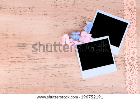 Blank old photos and decorative ribbon on color wooden background